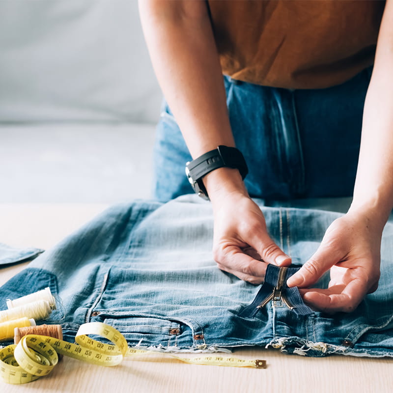 Woman,Repairs,Sews,Reuses,Fabric,From,Old,Denim,Clothes,Economical